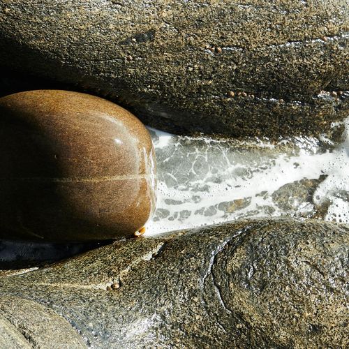 Water flowing smoothly over stones in a calm stream.